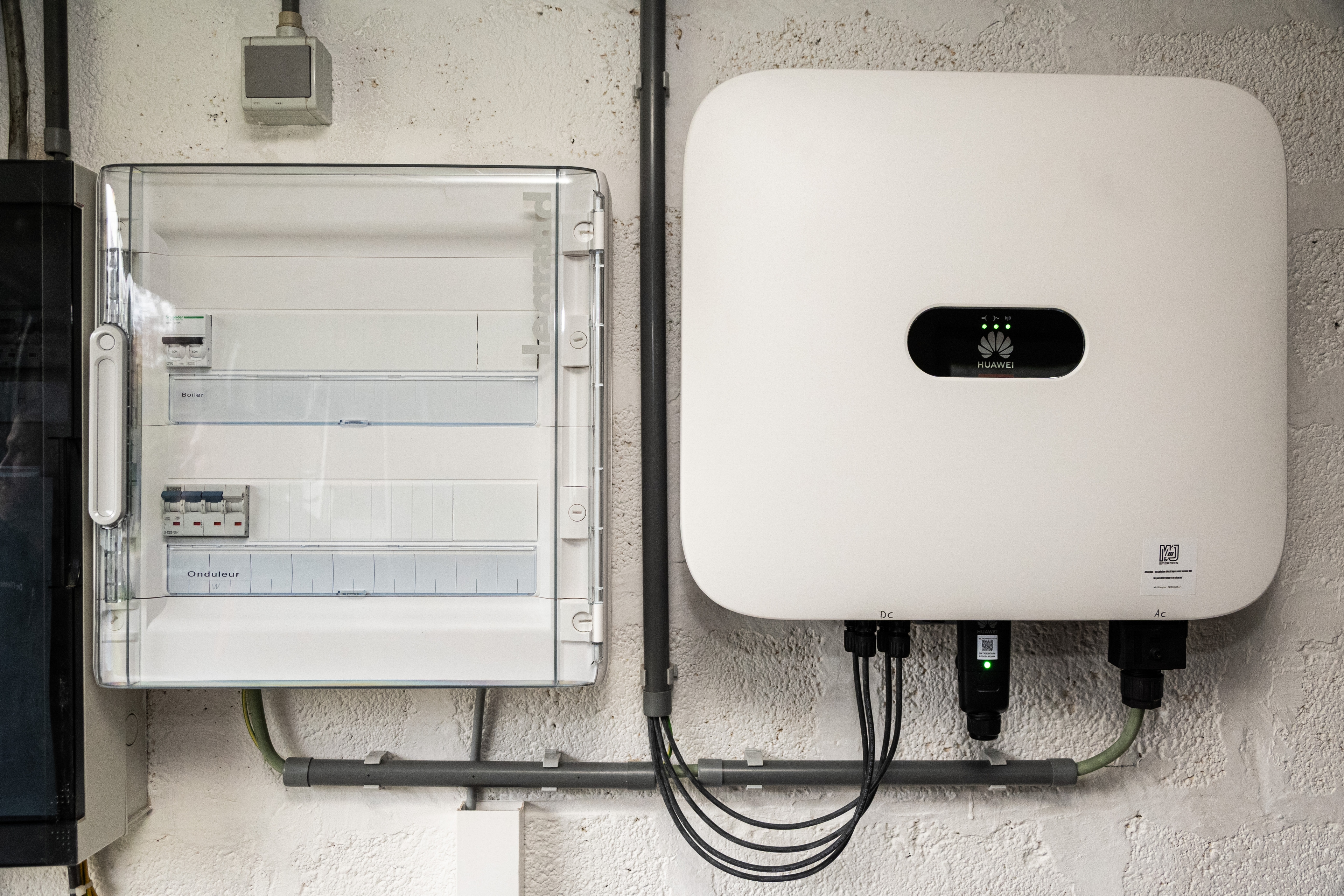 Onduleur et tableau electrique installes sur un mur.