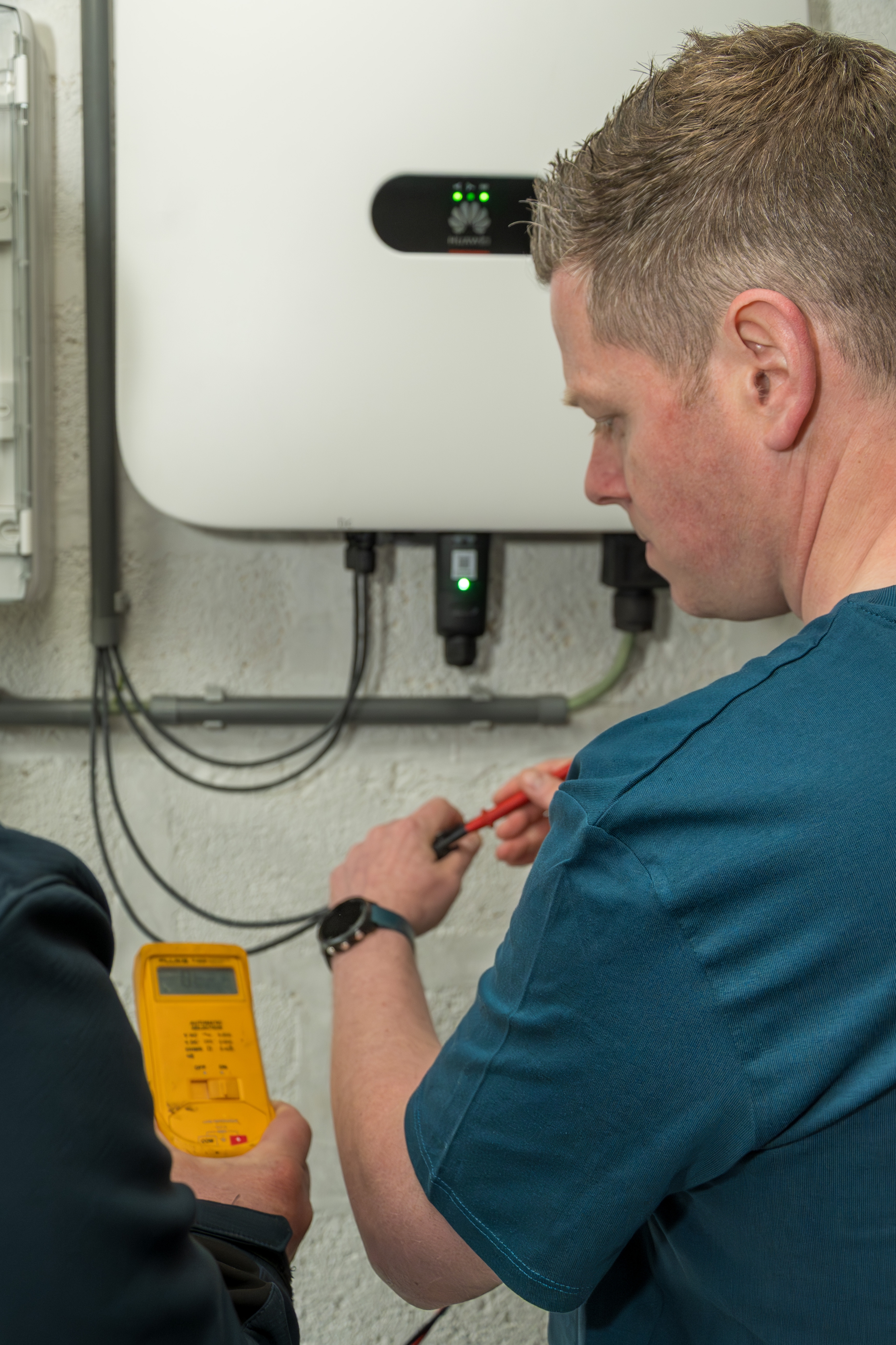 Technicien controlant une installation avec un appareil de mesure.